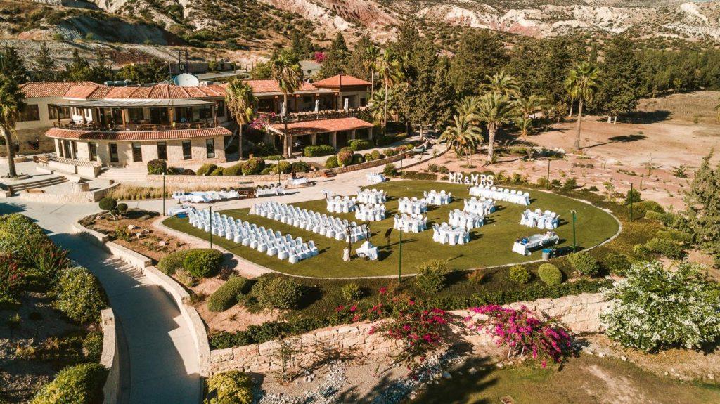Photograph looking down on Secret Valley Golf Resort Clubhouse Restaurant and events lawn out front set up with lots of white chairs for a wedding.