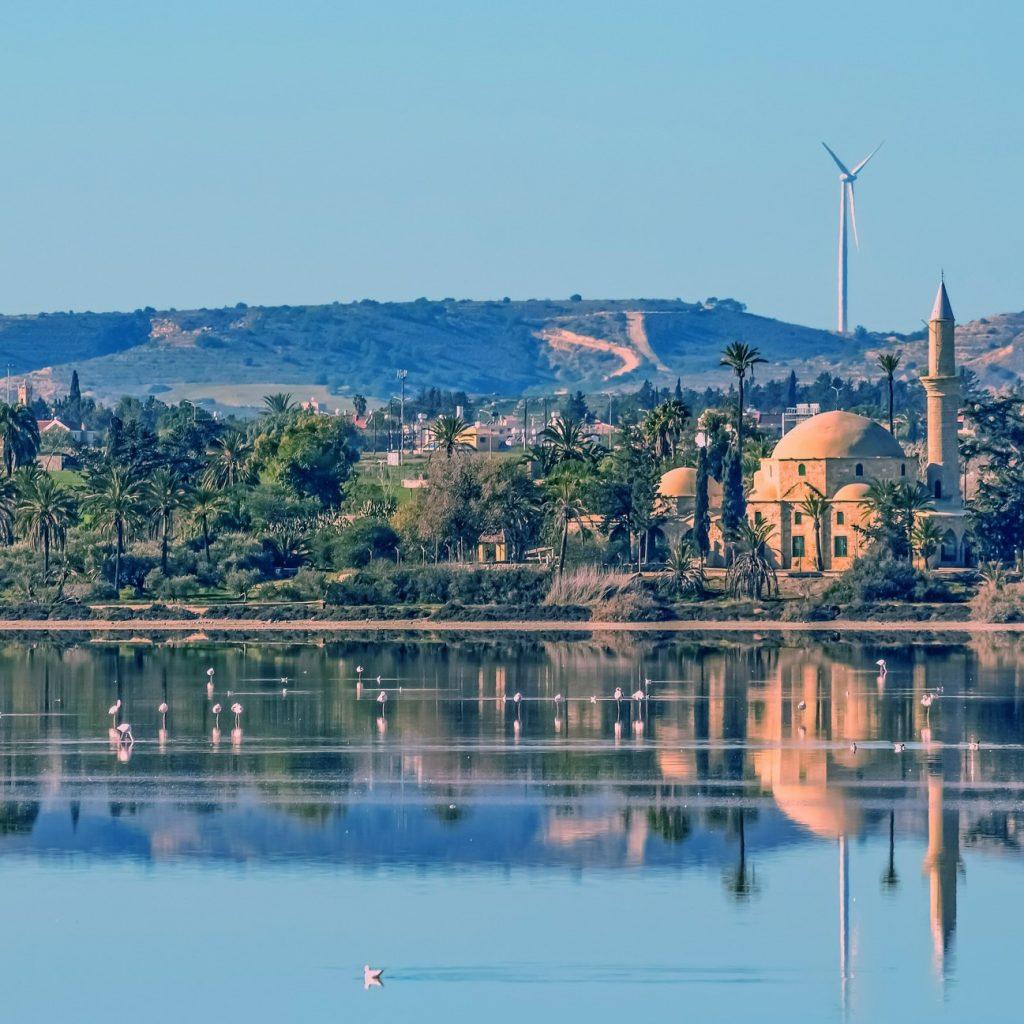View of the Hala Sultan Tekke mosque and its reflection in the salt lake at Larnaca. Flamingos in the waters.
