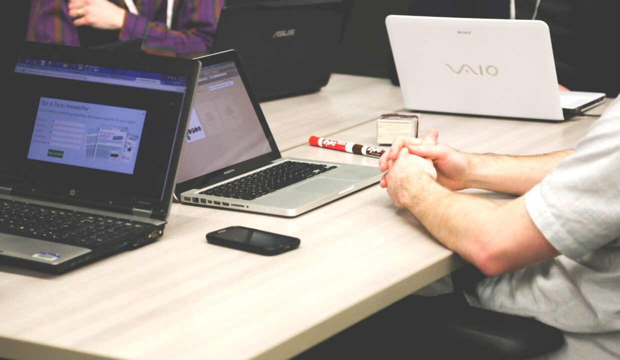 Photograph of an office desk with laptops and stationary - an office set up.