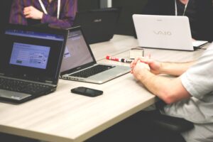Photograph of an office desk with laptops and stationary - an office set up.