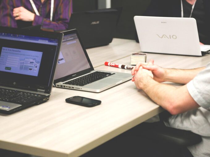 Photograph of an office desk with laptops and stationary - an office set up.